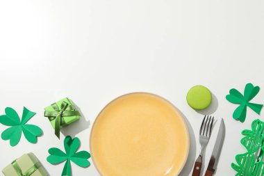 Çatal bıçak takımı, tabak, hediye kutuları ve yonca yaprakları beyaz arka planda, metin için boşluk