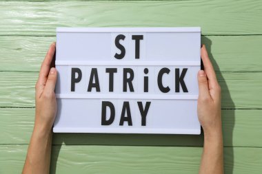 Yeşil ahşap arka plan, üst görünüm üzerinde kadın ellerinde metin içeren ışık kutusu