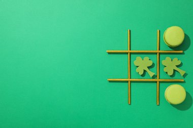 Kağıt yonca yaprakları, badem kurabiyeleri ve yeşil arka planda kokteyl pipetleri, metin için alan