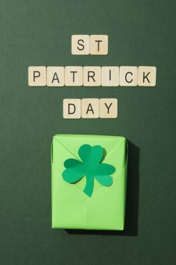 Yeşil kutuda yonca yaprağı ve ahşap harfler var.