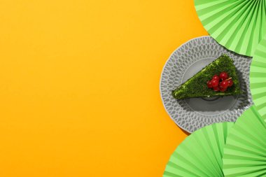 Tabakta ıspanaklı kek ve sarı arkaplanda kağıt süslemeler, metin için yer