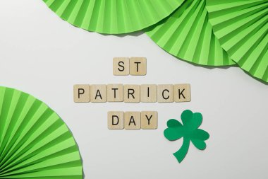 Kağıt süsleme ve yonca yaprağı, beyaz arka planda ahşap harfler, üst manzara.