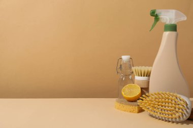 Bej arka planda fırçalar, süngerler, limon ve şişeler, metin için boşluk