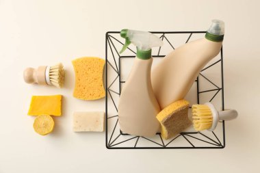 Sepetli şişeler, sabun, fırça ve süngerler bej arka planda, üst manzara