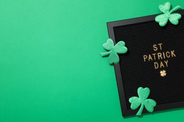 Üzerinde altın harfler ve yeşil arkaplanda kağıt yonca yaprakları olan siyah harfler tahtası, metin için boşluk