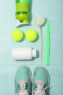 Spor kıyafetleri ve aksesuarlar, çiçeklerle, mavi bir arka planda..