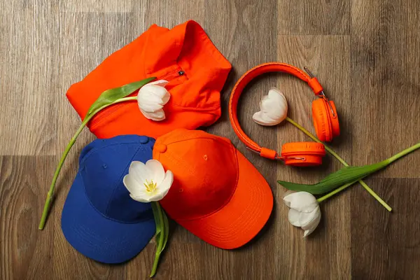 Sportswear and accessories, with flowers, on a wooden background.