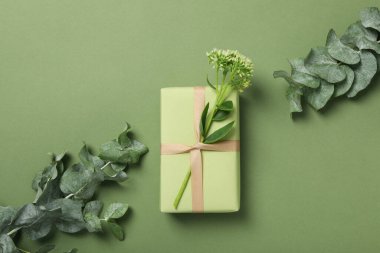 Yeşil arka planda çiçekli bir hediye..