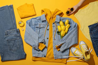 Kadın bahar gardırobu, çiçekler ve kadehler sarı arka planda, üst manzara