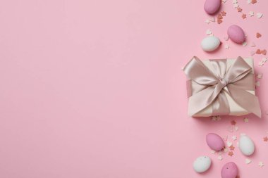 Pembe arka planda hediyeleri olan çikolatalı yumurtalar.