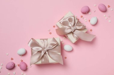 Pembe arka planda hediyeleri olan çikolatalı yumurtalar.