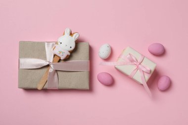 Pembe arka planda hediyeleri olan çikolatalı yumurtalar.