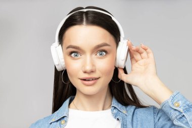 Kulaklıkla müzik dinleyen çekici genç bir kadın.