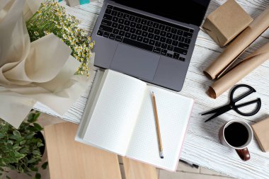 Bir çiçekçinin iş yeri, bir buket, bir dizüstü bilgisayar ve bir defter..