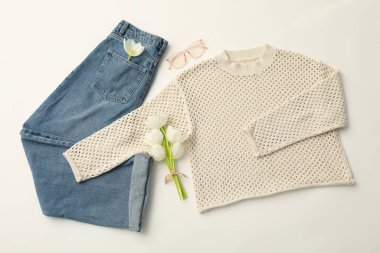 Kadın bahar kıyafeti ve beyaz arka planda çiçekler, üst manzara.