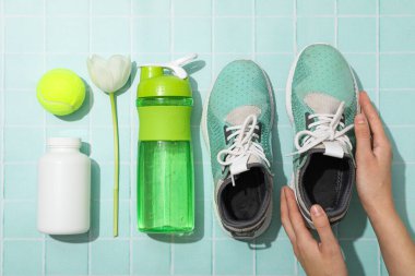 Spor kıyafetleri ve aksesuarlar, çiçeklerle, mavi bir arka planda..