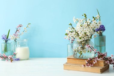 Mavi arka planda çiçekli bahar dalları.