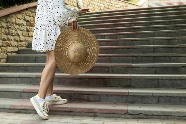 Девушка держит корзину с цветами на улице, летом.