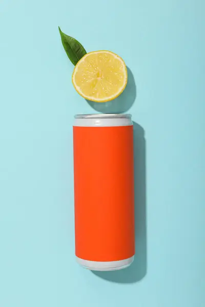 Tin can and lemon on blue background, top view