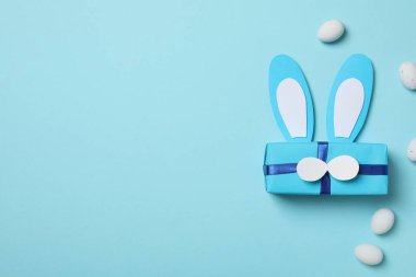 Mavi arka planda tavşan kulaklı mavi hediye kutusu