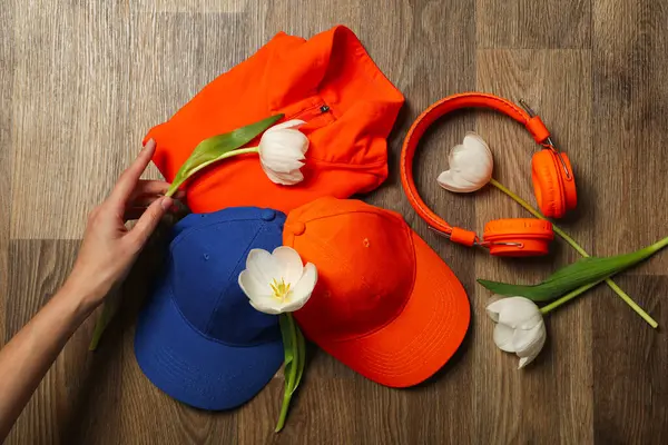 Sportswear and accessories, with flowers, on a wooden background.