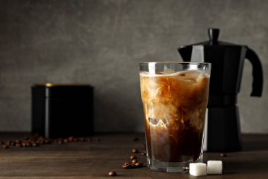 Buzlu kahve içeceği, kahve makinesi, kahve çekirdeği ve şeker gri arka planda, mesaj için yer var.