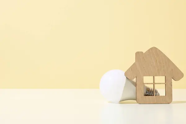 Decorative house with a light bulb on a light background