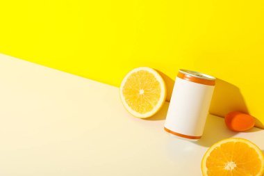 Sarı arkaplanda teneke kutu ve portakallar, metin için boşluk