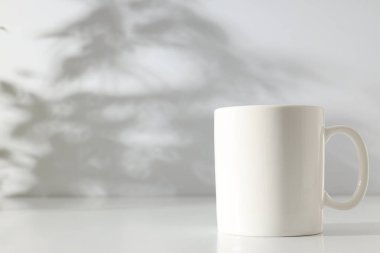 Hafif arka planda beyaz klasik kupa