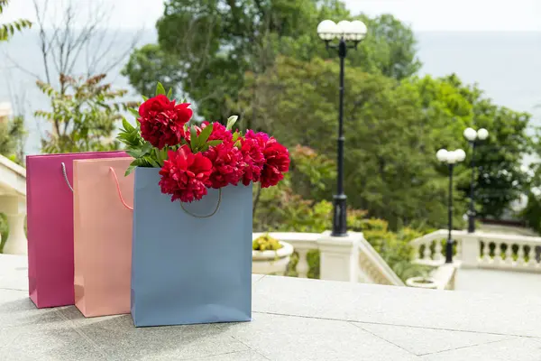 Flowers in paper, gift bags, on the street.