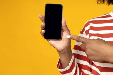 Elinde akıllı telefonuyla genç bir Afrikalı Amerikalı kadın.