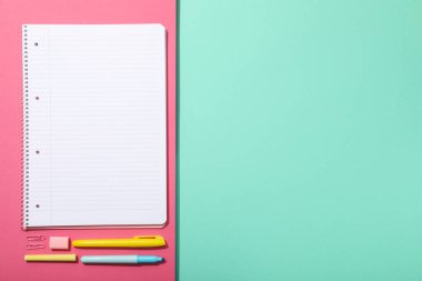 Masanın üzerinde defter ve kırtasiye malzemesi, üst görünüm.