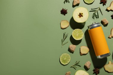 Zencefil kökü, elma ve kireç parçaları ve yeşil arkaplanda teneke kutu, metin için boşluk