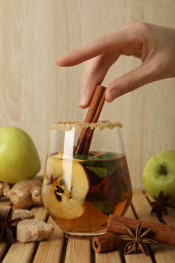 Elma şırası, tarçın çubuğu, ahşap zeminde elma ve baharat.