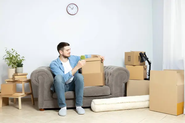 Moving concept, man with boxes in apartment.
