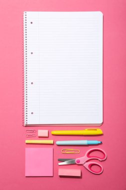 Masanın üzerinde defter ve kırtasiye malzemesi, üst görünüm.