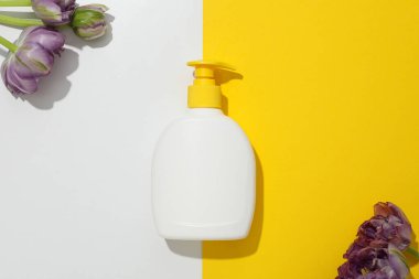 Taze çiçekli bir şişe deterjan.