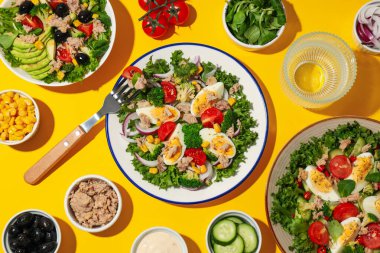 Sarı arka planda ton balıklı salata..