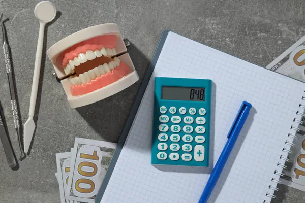 Szczęka Instrumenty Dentystyczne Kalkulator Gotówka Notatnik Szarym Tle Widok Góry — Zdjęcie stockowe