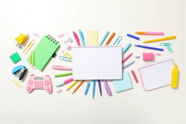 Masanın üzerinde defter ve kırtasiye malzemesi, üst görünüm.