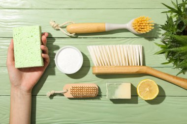 Temizlik aletleri, doğal temizlik ürünleri ve yeşil ahşap arka plan, üst görünüm
