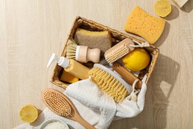 Temizlik aletleri ve açık ahşap zemin üzerine havlu dolu sepet, üst görünüm