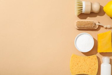 Soda, limon, sabun, sünger, bej arka planda fırça ve şişe, metin için boşluk
