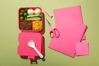 Yemek, makas ve pembe kağıtlı pembe beslenme çantası.
