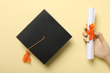 Sarı arka plan diploması ve şapkası var..