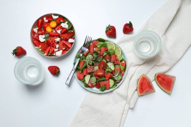 Beyaz arka planda çilekli karpuz salatası.