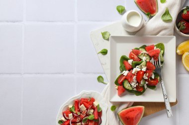 Beyaz arka planda limonlu ve çilekli karpuz salatası.