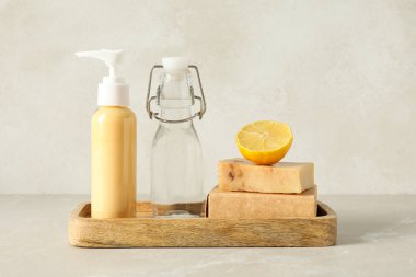 Deterjan, limon ve arka planda sabun bulunan şişeler.