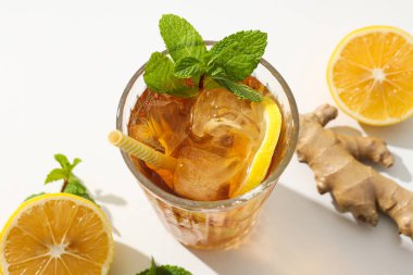 Cold tea with ice, orange slices and mint leaves and ginger clipart