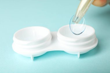 Plastik cımbız temiz bir göz merceği tutar.